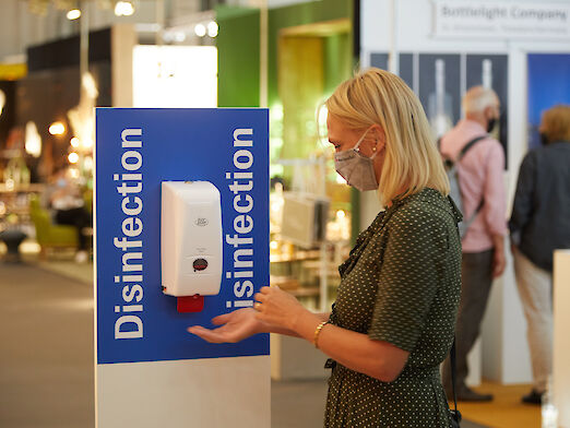 Trade show visitor at a disinfection dispenser